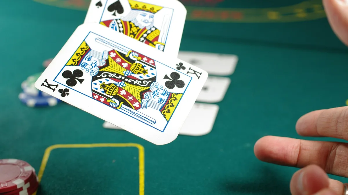 Kartu dibagikan di meja kasino hijau dengan tumpukan chip sebagai ilustrasi game show live casino
